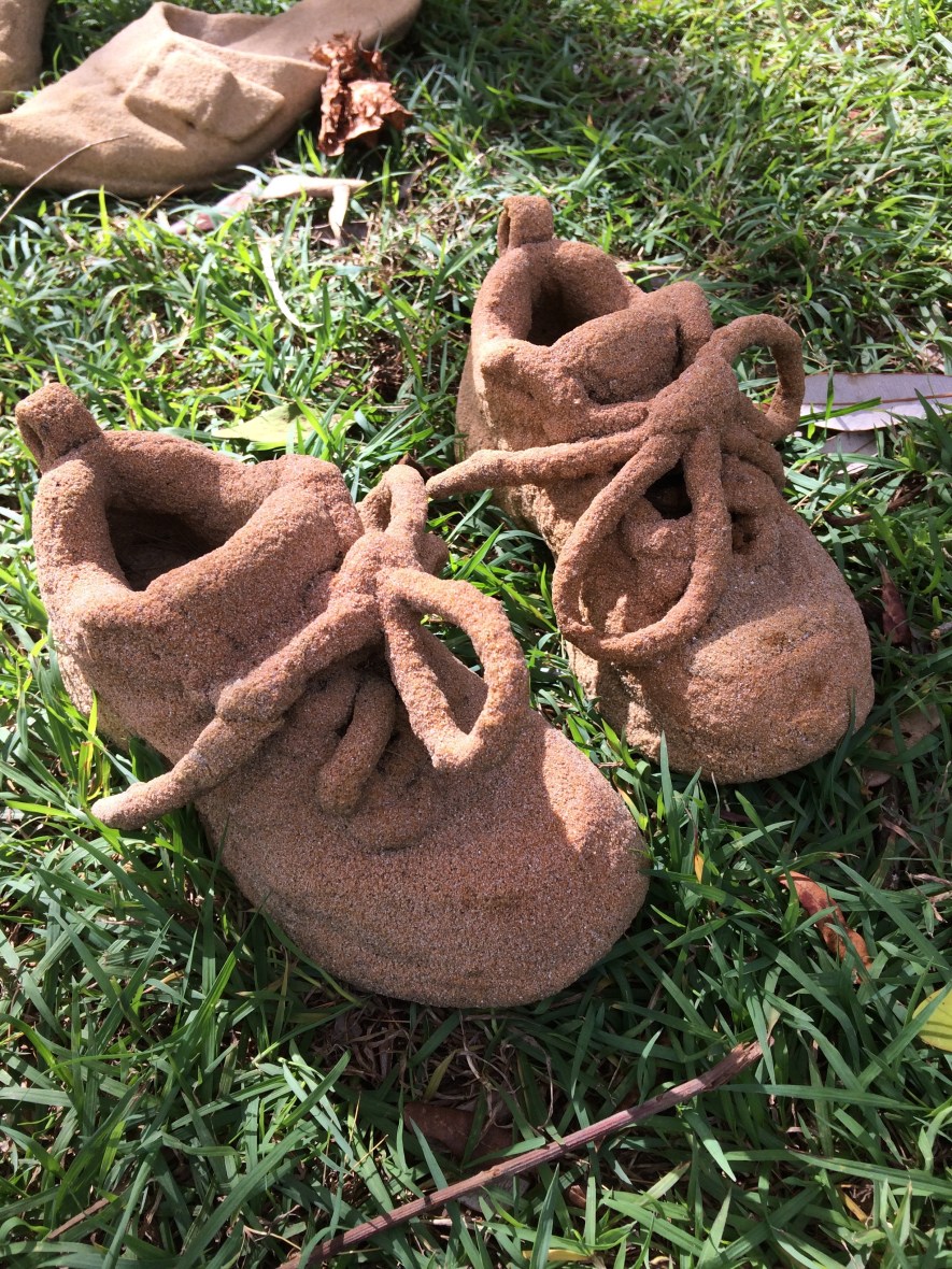 Sandy shoe sculptures brighten my beach walk